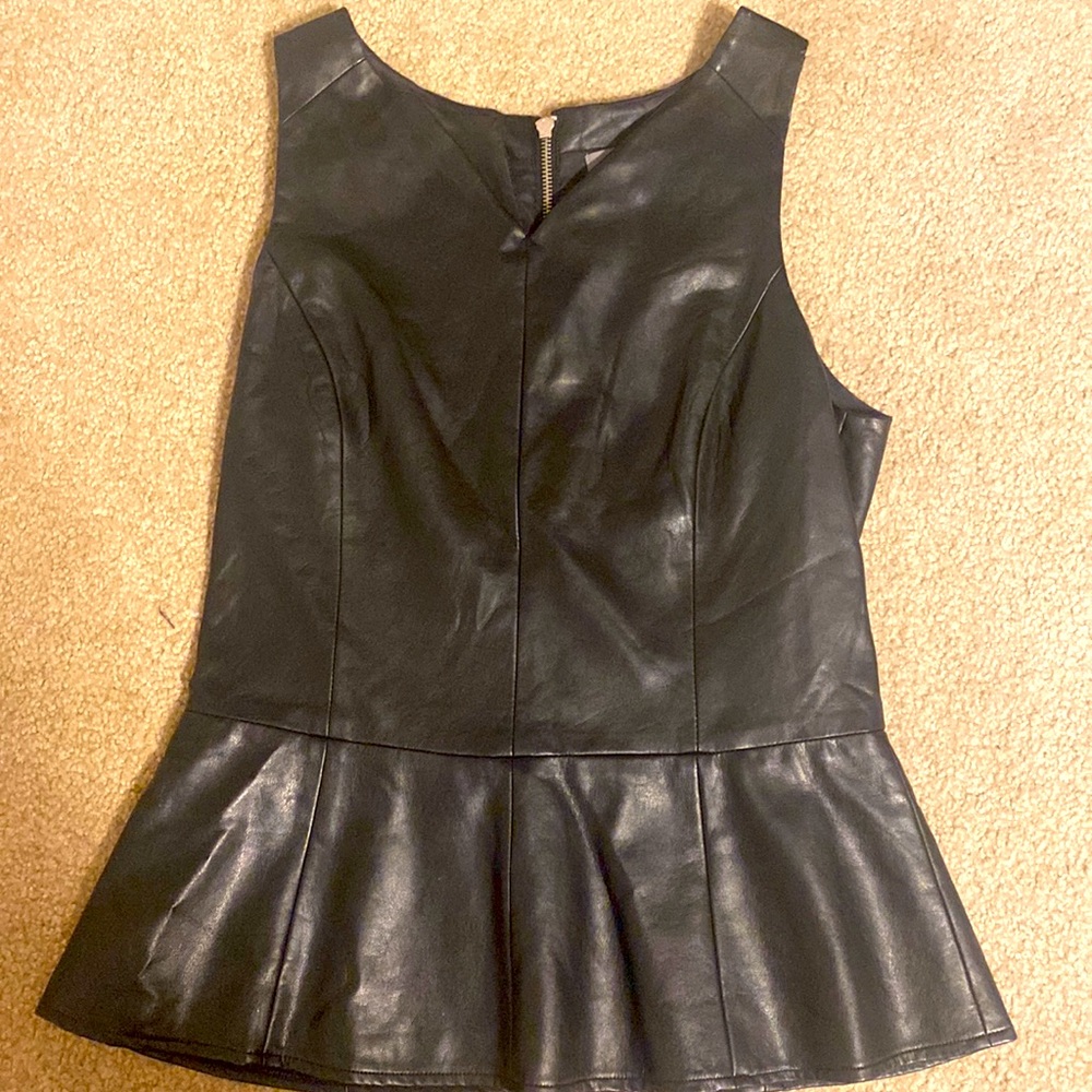 Faux leather peplum top. Stretch panel in back with chrome zipper. Sexy & fun